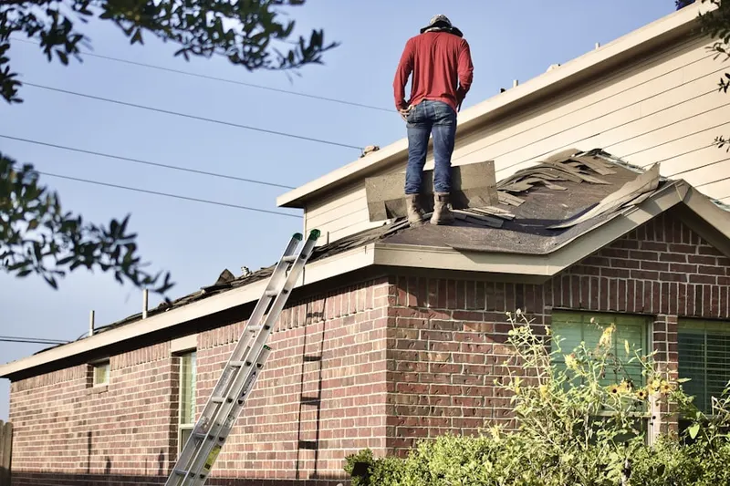 Professional roofer working on a residential roof in Solvay